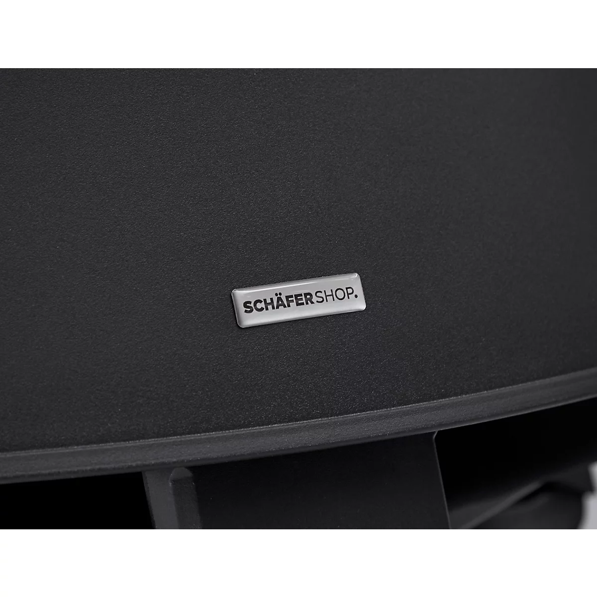 Close-up van een zwart materiaal met een zilveren bordje met de tekst SCHÄFERSHOP.