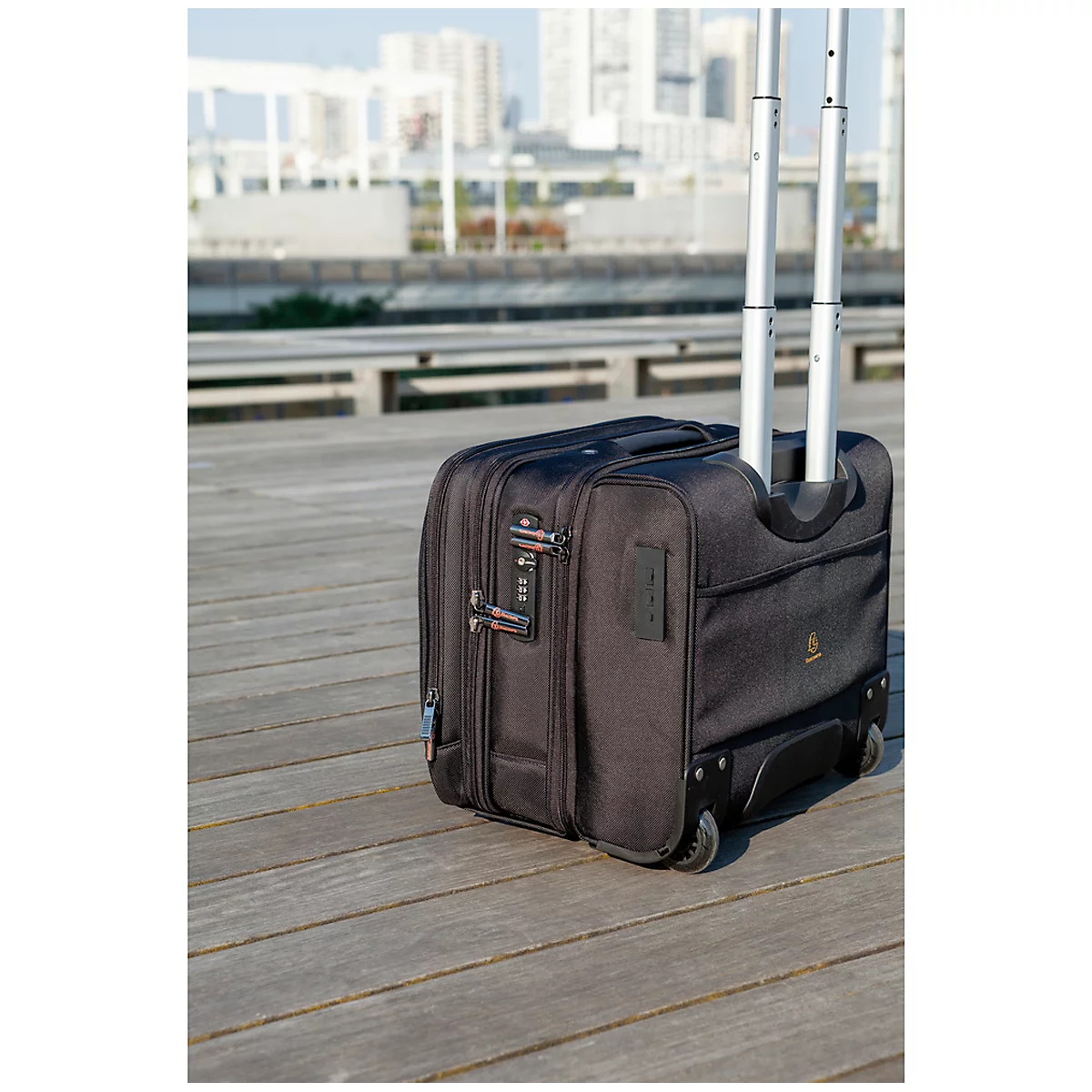 Black rolling suitcase on wooden planks. City view in the background.