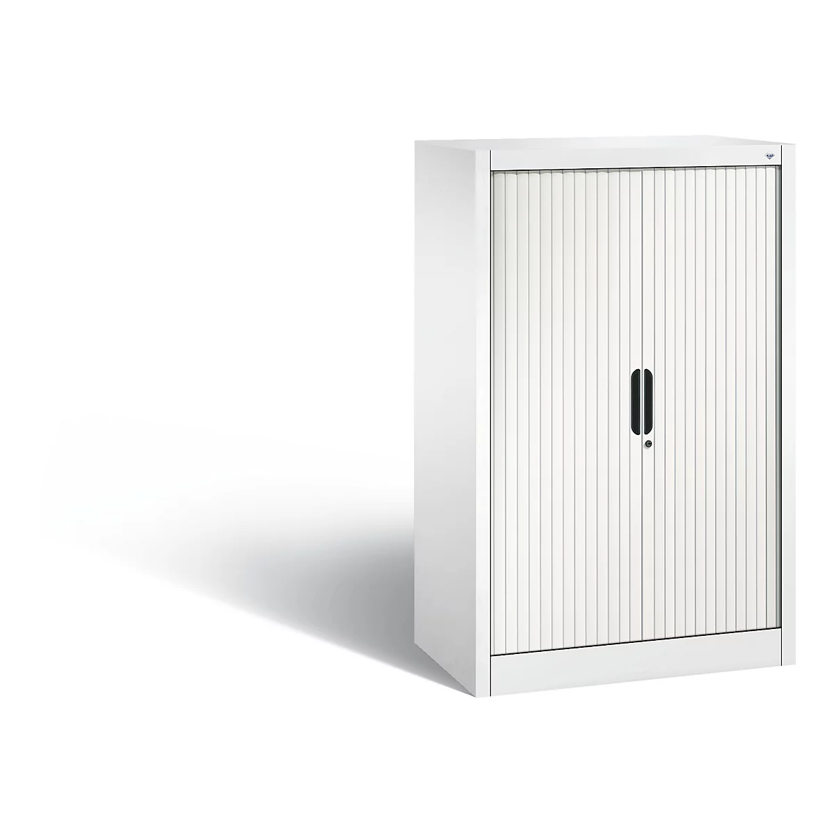 Armoire à rideaux blanche projetant une ombre. Le meuble a une façade nervurée et une poignée noire.