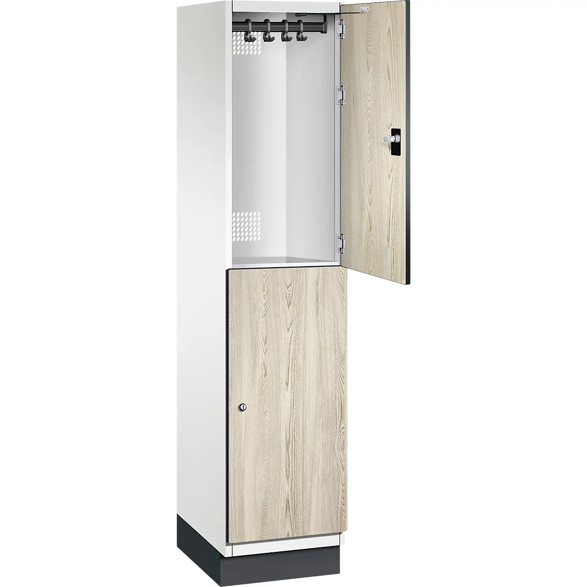 Ein weißer Spind mit teilweise geöffneten Türen, die Tür aus Holz, oben Kleiderhaken.