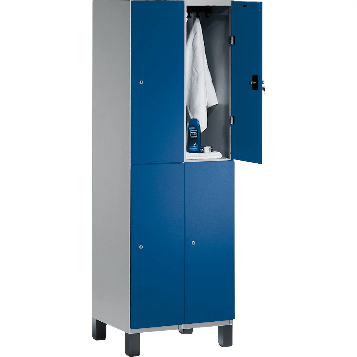 Ein blauer Spind mit geöffneter Tür. Im Inneren hängen ein weißes Hemd und Kosmetikartikel auf einem Regal.