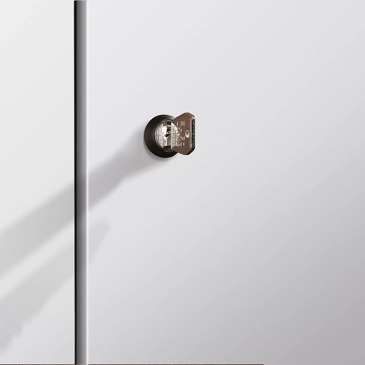 Nahaufnahme eines Schlüssellochs mit Schlüssel vor weißem Hintergrund.