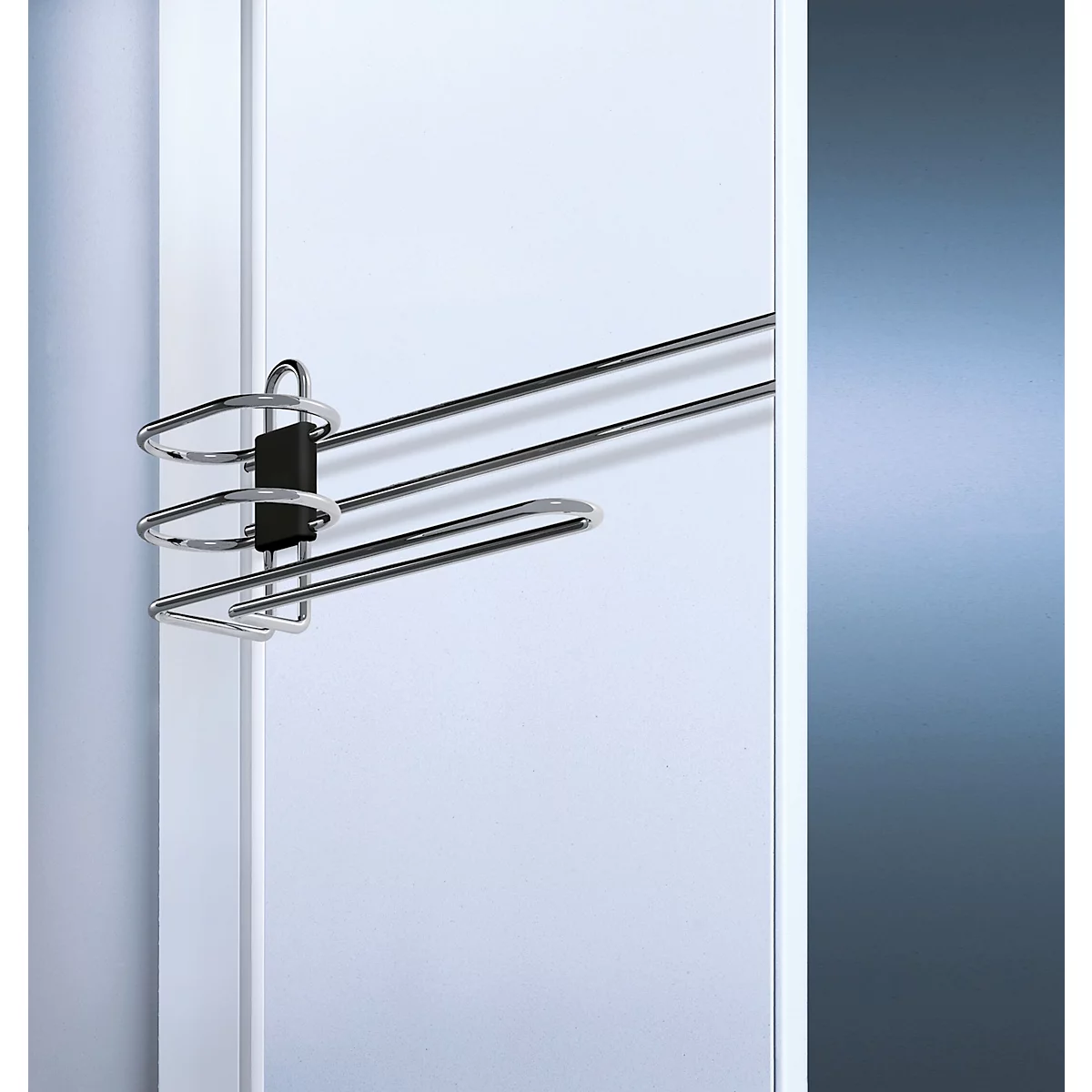 Ein Chrom-Hosenbügel mit drei Stangen an einer weißen Tür.