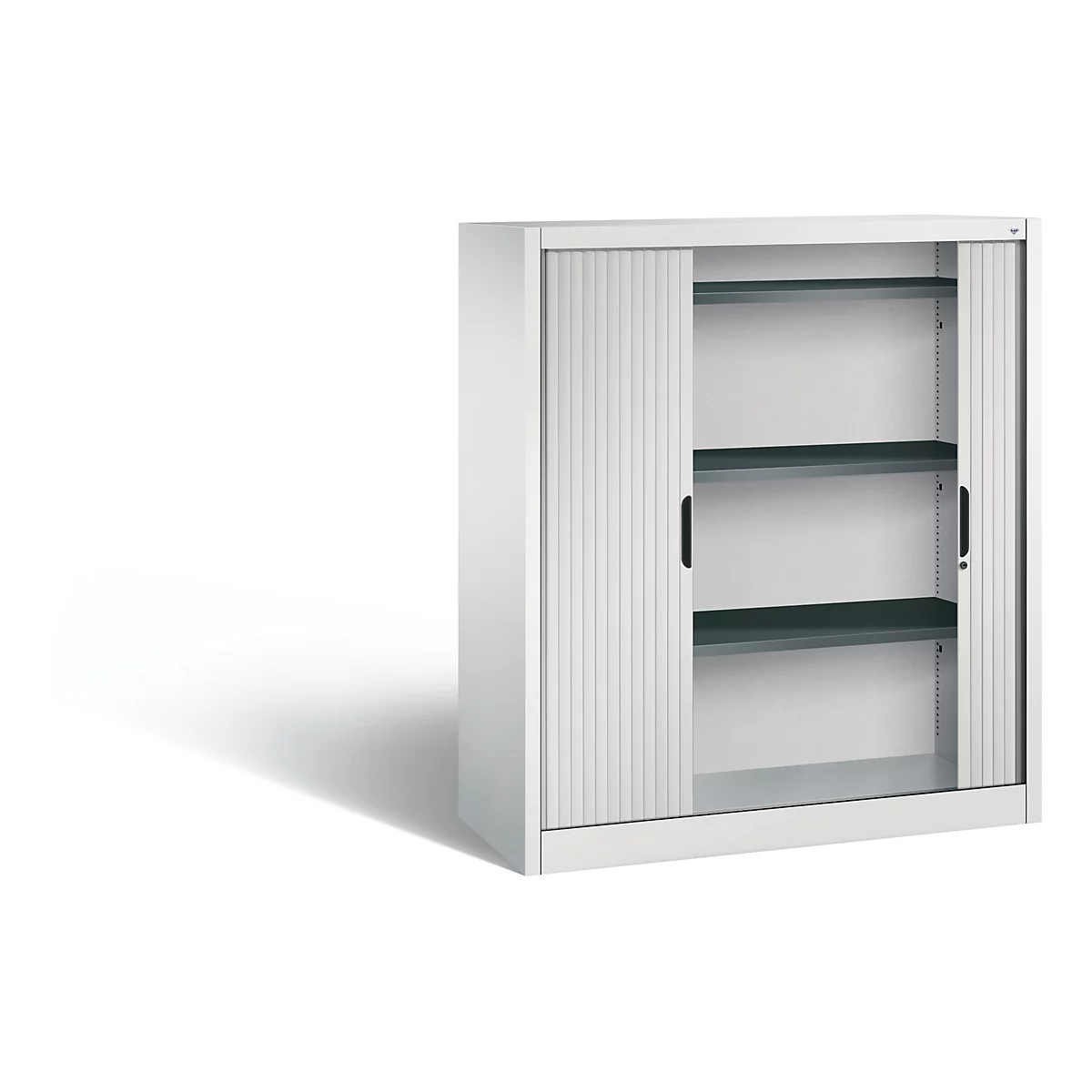 White cabinet with roller shutter, two black handles and three shelves. Cabinet stands against a white background.