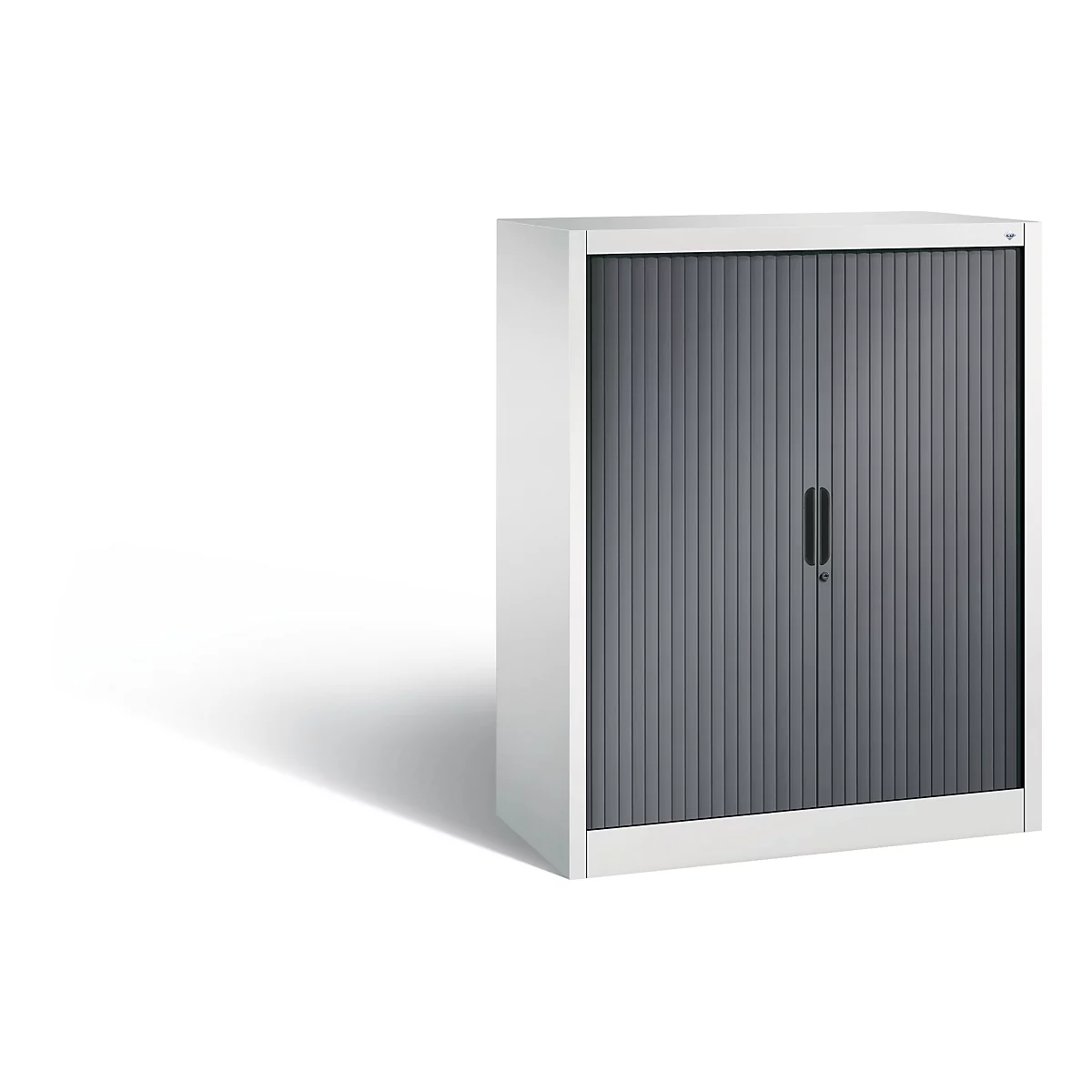 Kast met grijze rolluik. Witte kast, grijze deur met verticale lamellen, zwarte handgreep.