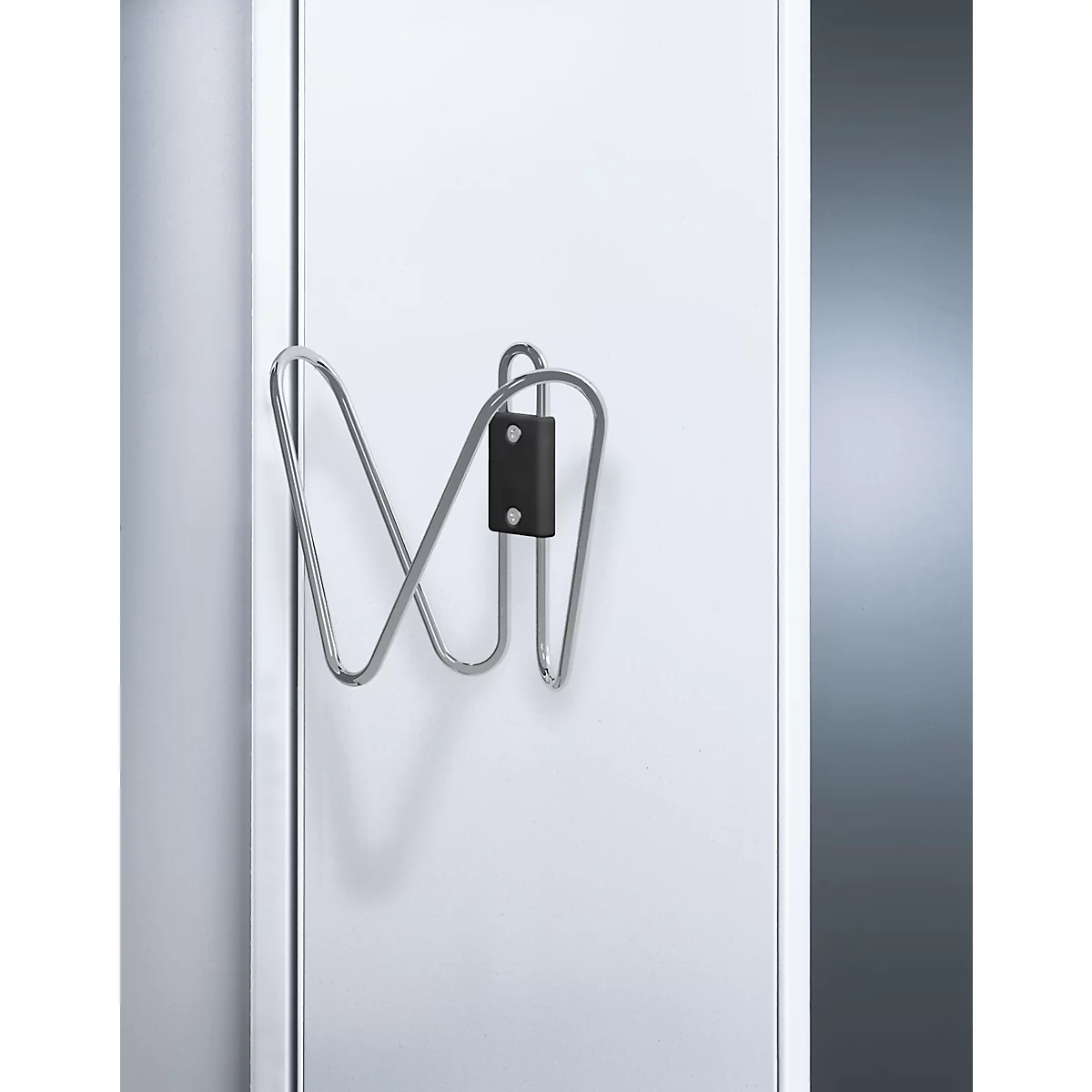 Metall-Fahrradhalterung an weißer Tür. Schwarzer Halter, gebogene Metallhalterung.