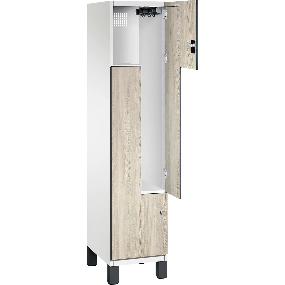 Offener, weißer Spind mit Holzoptik-Türen. Innenraum ist weiß, mit Haken und Regalen. Schwarze Füße.