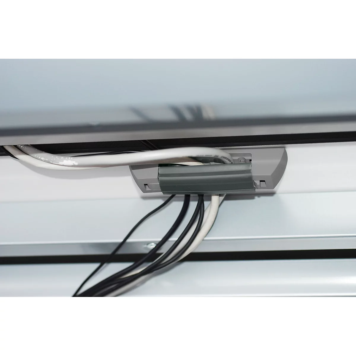 Gray cable duct with cables, white panels above and below, black frame.
