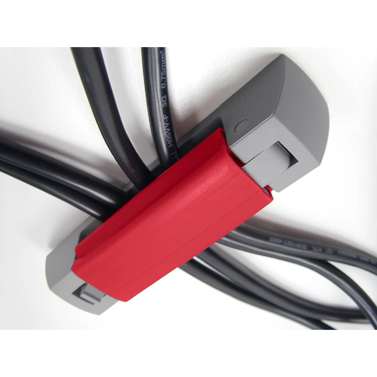 Gray cable clamps hold black cables, a red closure closes the clamps.