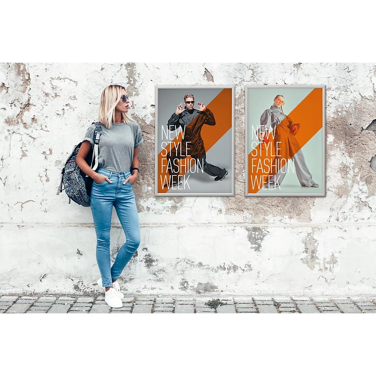 Une femme avec un sac à dos s'appuie contre un mur affichant deux publicités pour une Fashion Week.