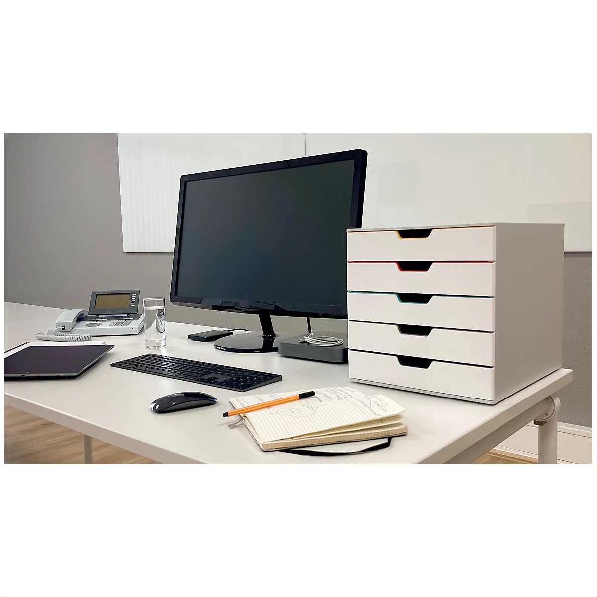 Escritorio con computadora, cajones, teclado, ratón y bloc de notas. Enfoque en los cajones.