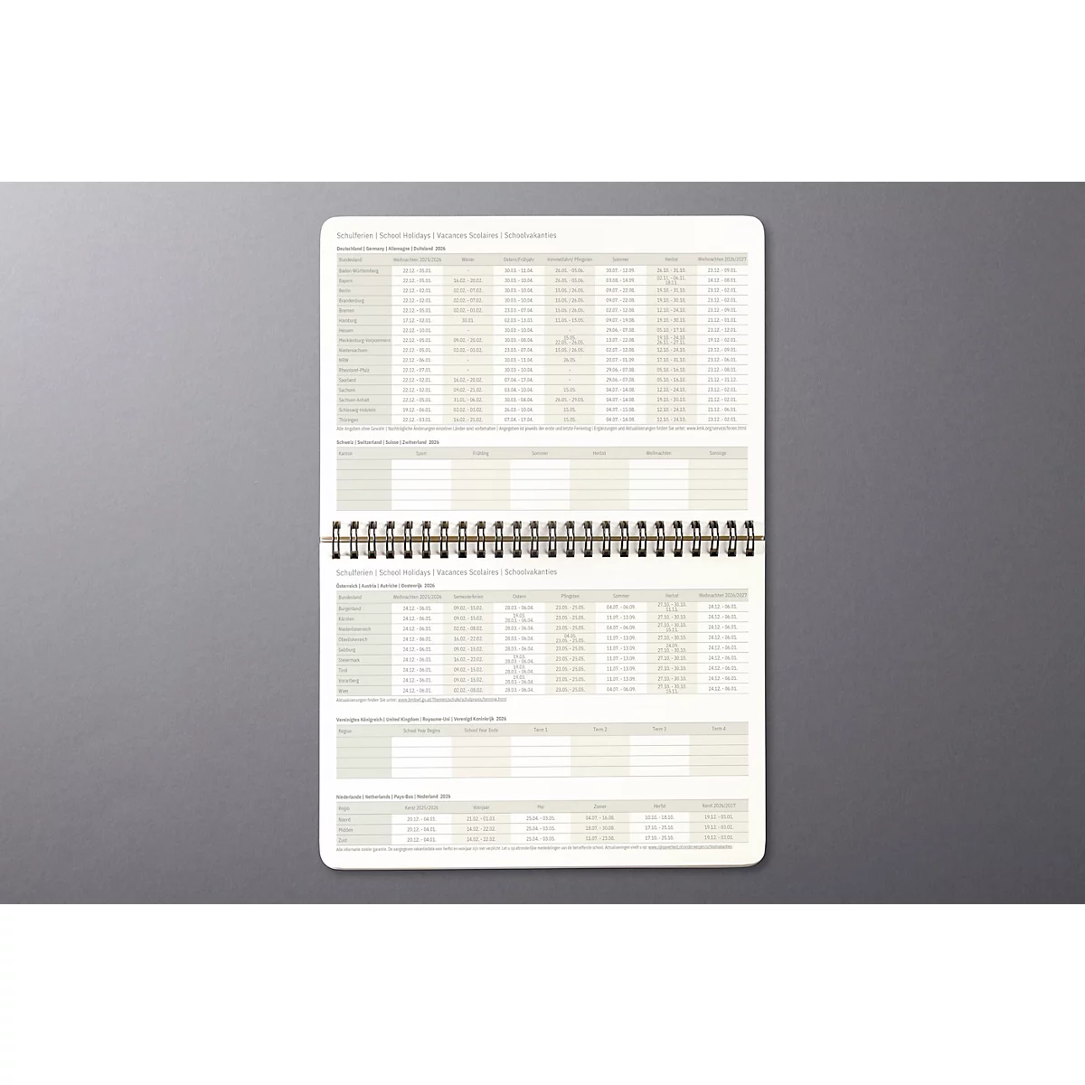 Bloc-notes à spirale. Les pages sont remplies de tableaux et de colonnes.