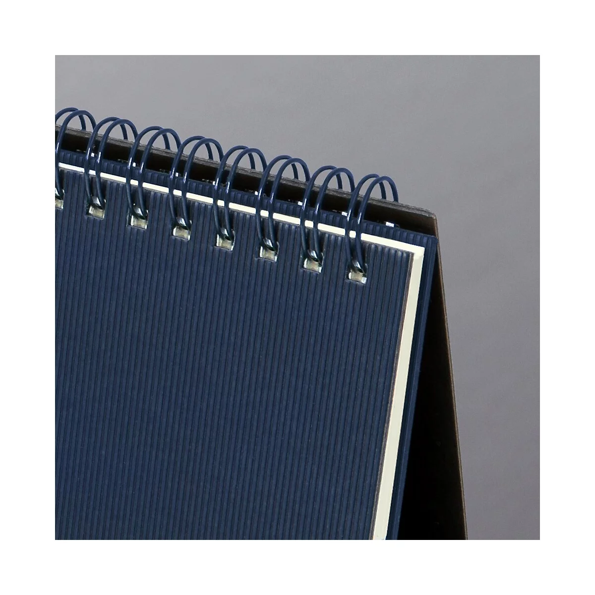 Gros plan sur un calendrier de bureau bleu avec reliure à spirale.