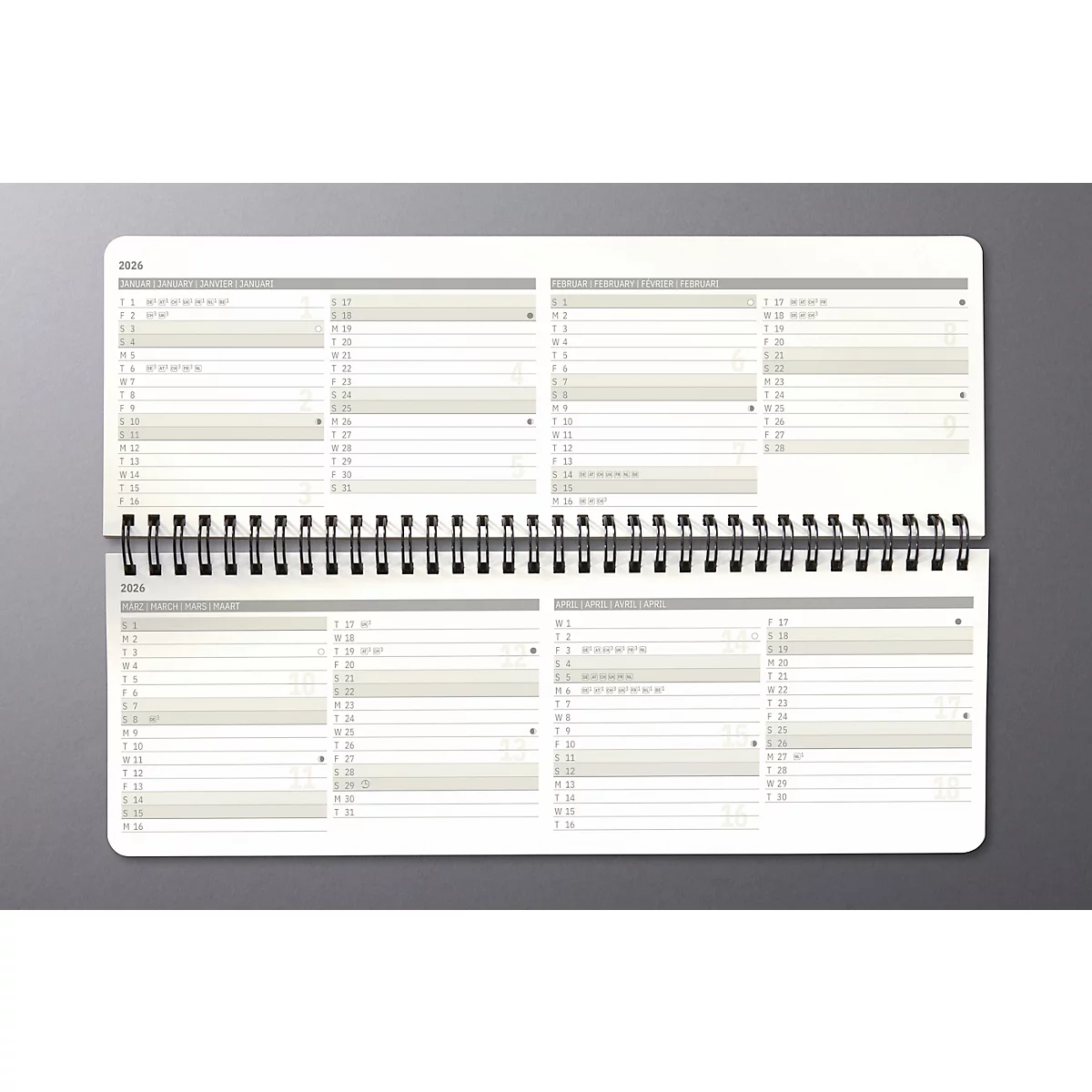 Calendrier annuel blanc ouvert avec reliure à spirale. Plusieurs colonnes pour la vue d'ensemble des dates sont disponibles sur chaque page.