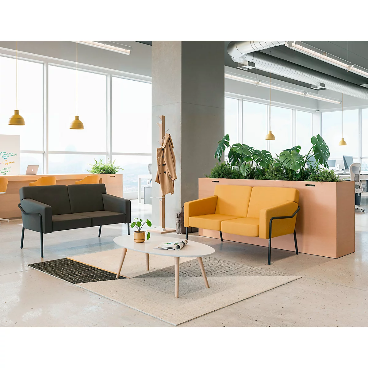Bureau avec deux canapés, une table basse, des plantes et un porte-manteau.