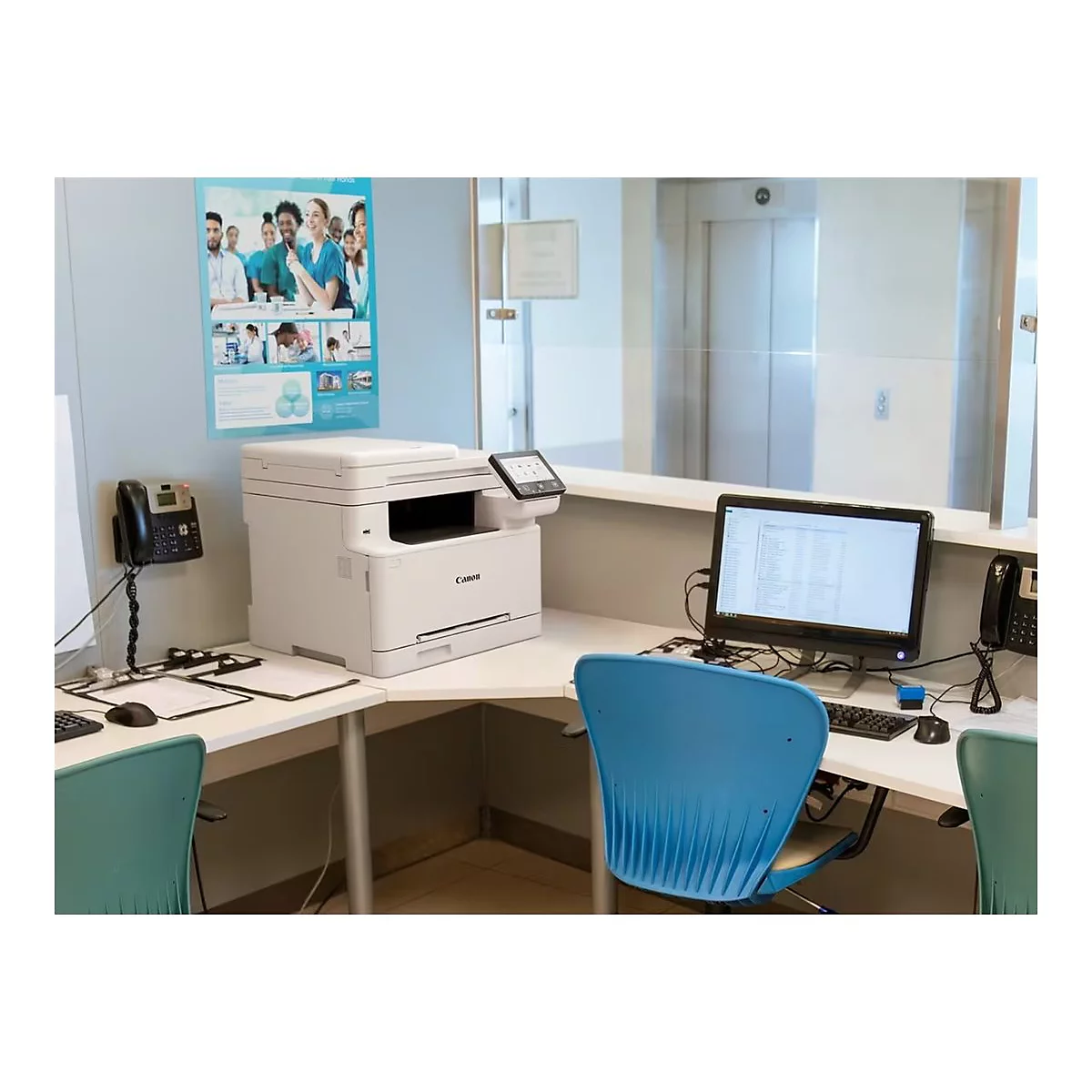 Ein weißer Canon-Multifunktionsdrucker auf einem Empfangstresen. Ein Computer, Telefon und Stühle sind ebenfalls im Bild.