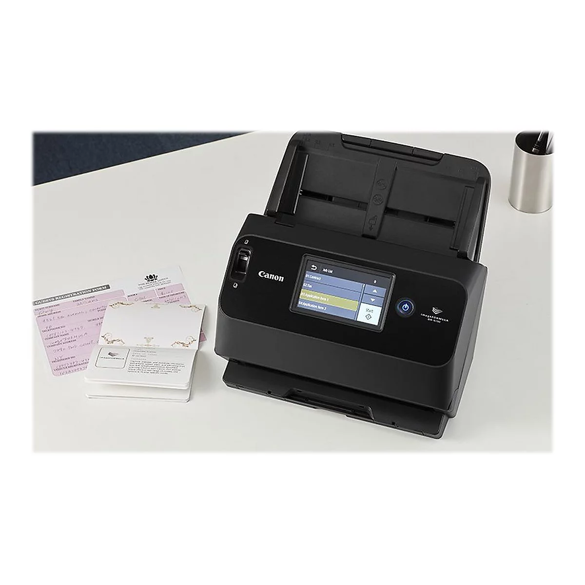 Ein schwarzer Canon-Scanner steht auf einem weißen Tisch neben Dokumenten und einem Becher. Auf dem Bildschirm werden Menüpunkte angezeigt.