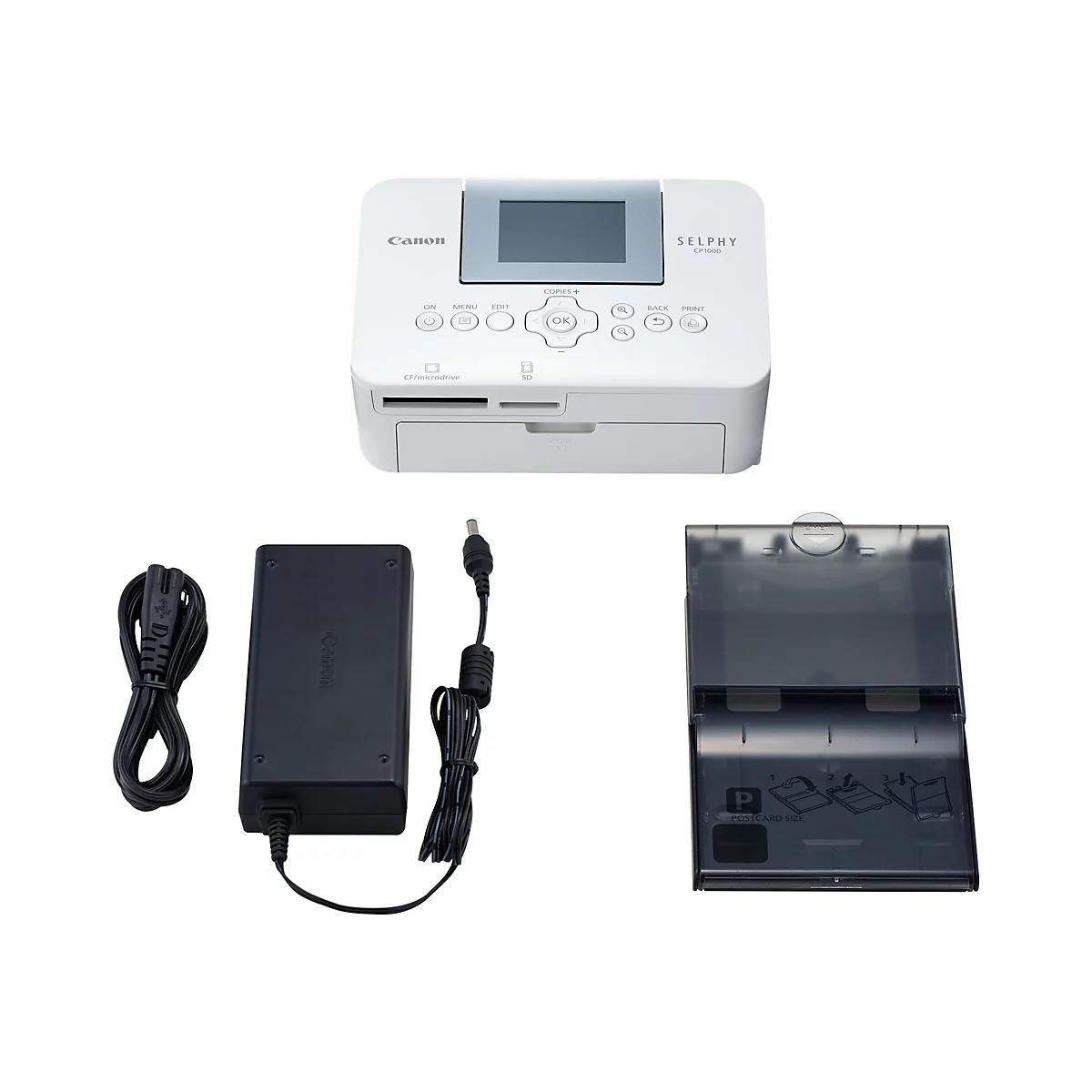 Ein weißer Canon Selphy CP1000 Fotodrucker mit Zubehör: Netzteil, Netzkabel, Papiereinzug. Auf weißem Hintergrund.