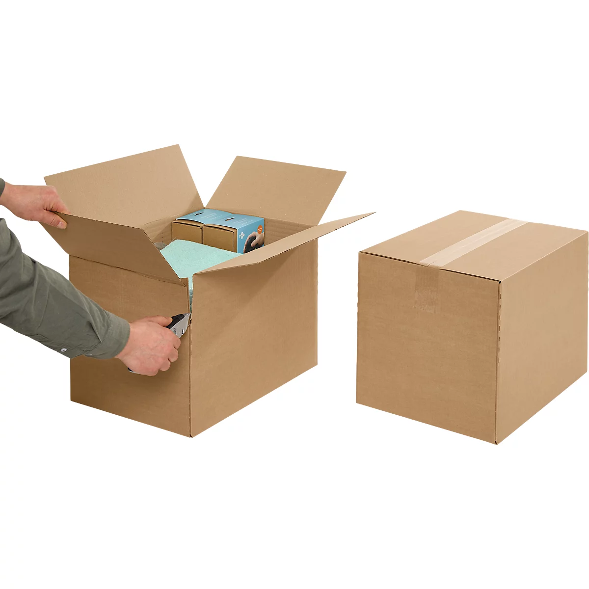 Person opens cardboard box with a knife, next to it a closed box.