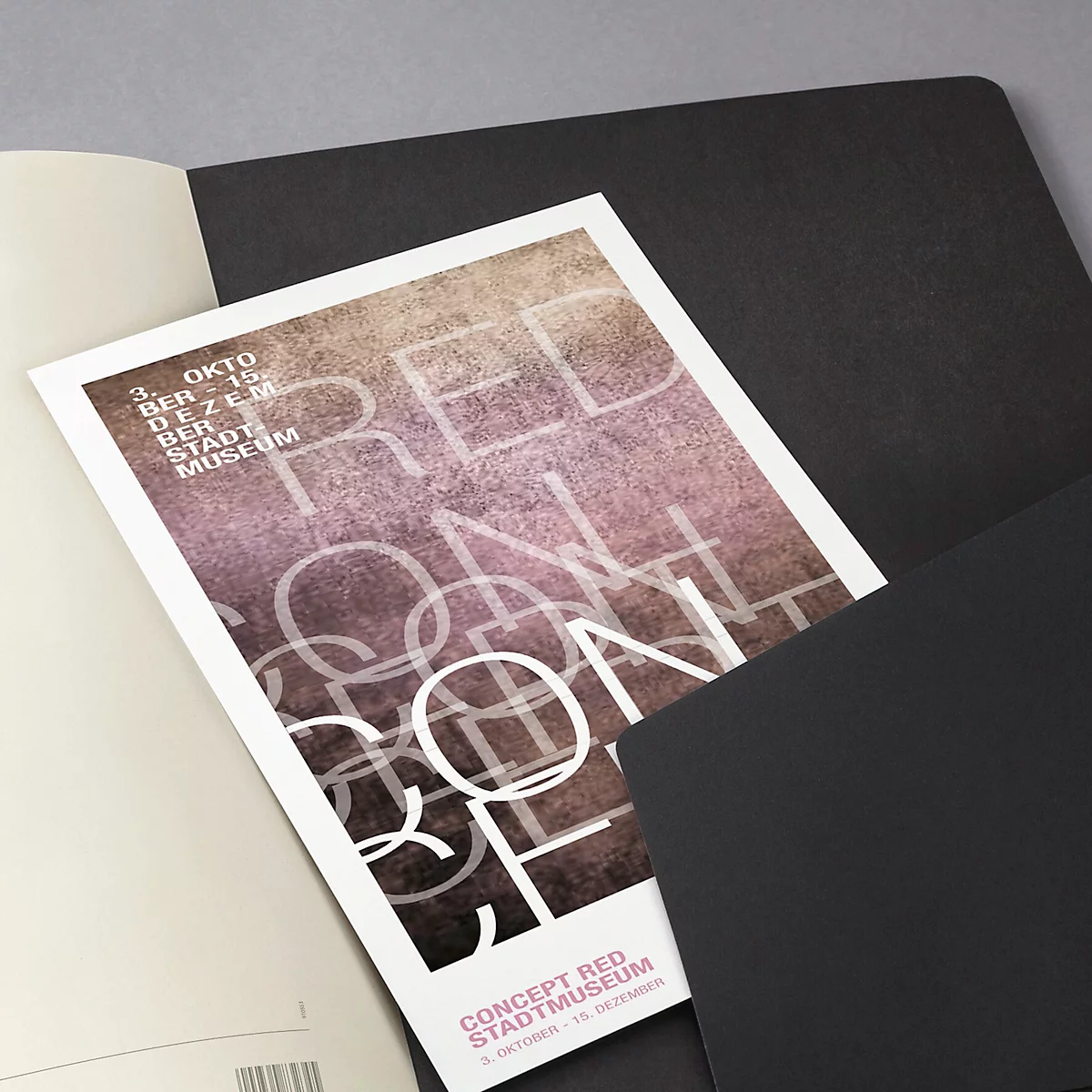 Affiche avec l'inscription "RED CONCEPT" sur des carnets. Feuilles noires et fond gris. Date en haut à gauche: 3 octobre au 15 décembre.