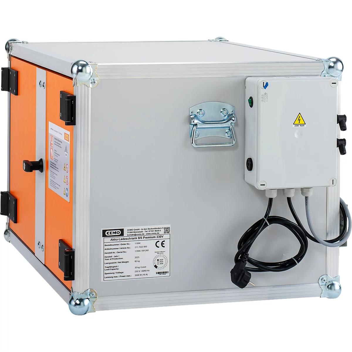 Grauer Koffer mit orangefarbenem Rahmen und einer weissen Box mit einem gelben Dreieck. Schwarzes Stromkabel.