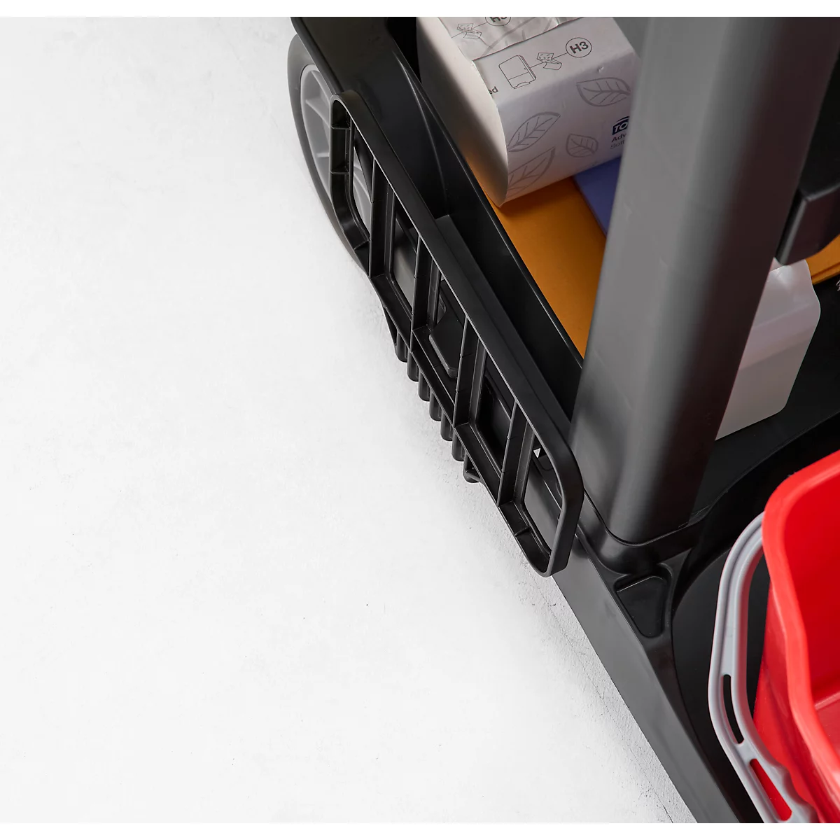 Gros plan d'un chariot de nettoyage noir avec divers produits de nettoyage et un seau rouge.