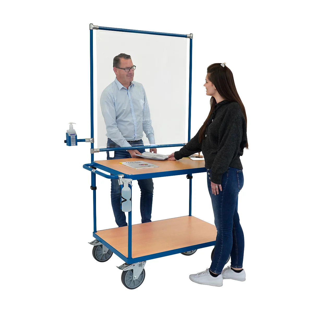 L'homme remet une brochure à une femme. Chariot de comptoir avec protection hygiénique, distributeur de désinfectant.