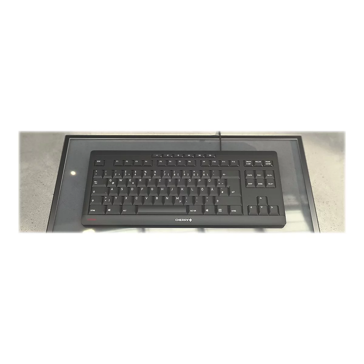 Schwarze Tastatur auf einer Glasplatte, das Cherry-Logo ist sichtbar.