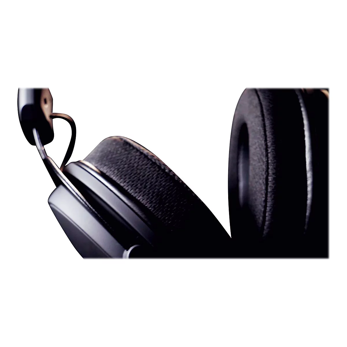 Nahaufnahme eines schwarzen Kopfhörers vor weißem Hintergrund. Der Fokus liegt auf dem Ohrpolster.