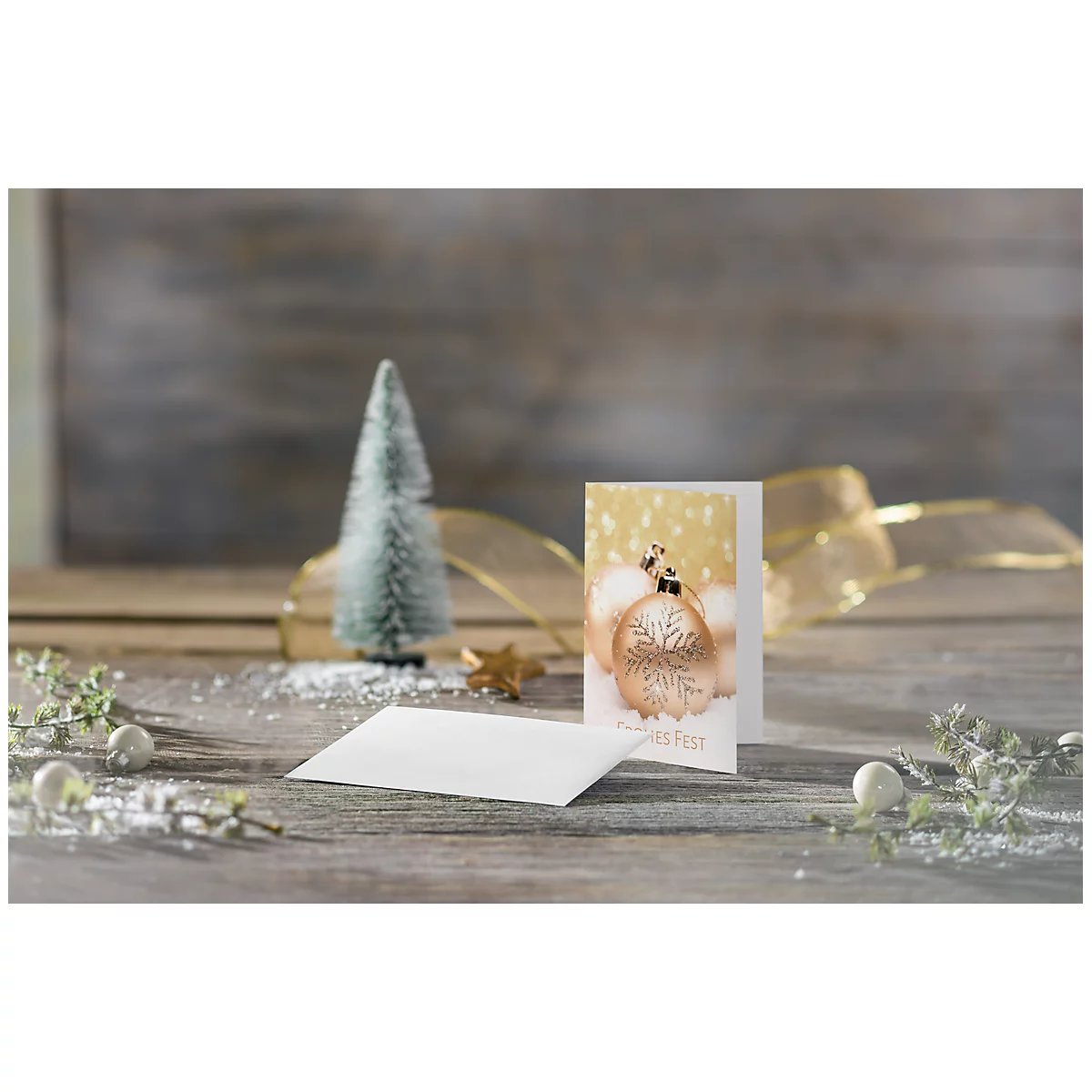Christmas card with baubles, Christmas tree, star and envelope on wooden background.