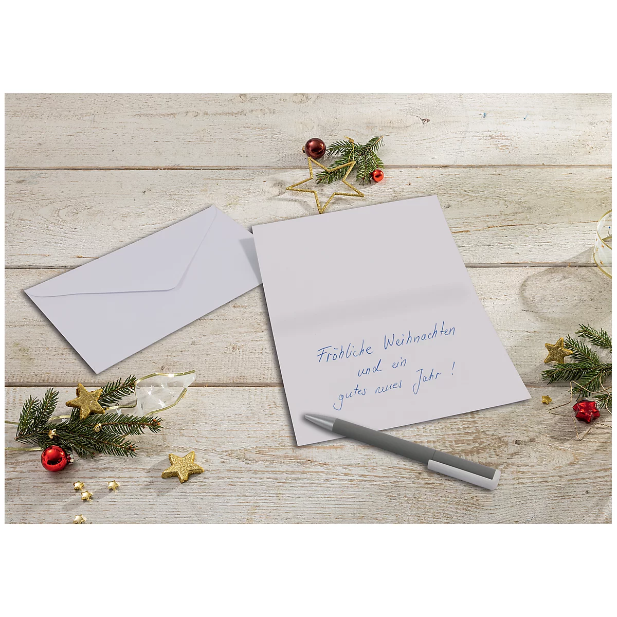 Christmas card with greeting "Merry Christmas and a Happy New Year!", ballpoint pen, decorations on a wooden surface.