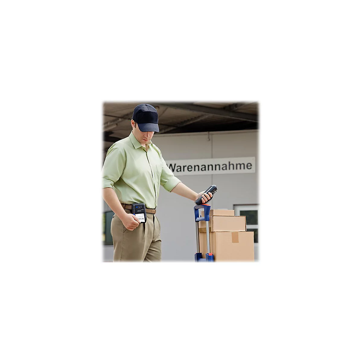Ein Mann in Arbeitskleidung scannt Waren bei der Warenannahme, mit einer Box und einem Handscanner.