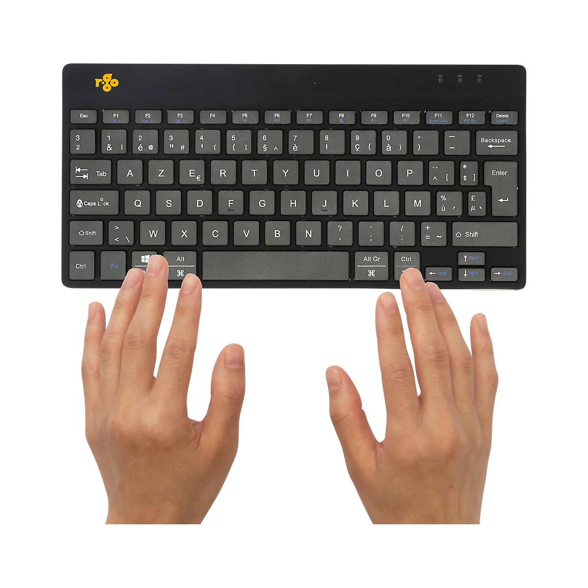 Une personne utilise un clavier noir avec des touches grises. Les mains sont visibles.