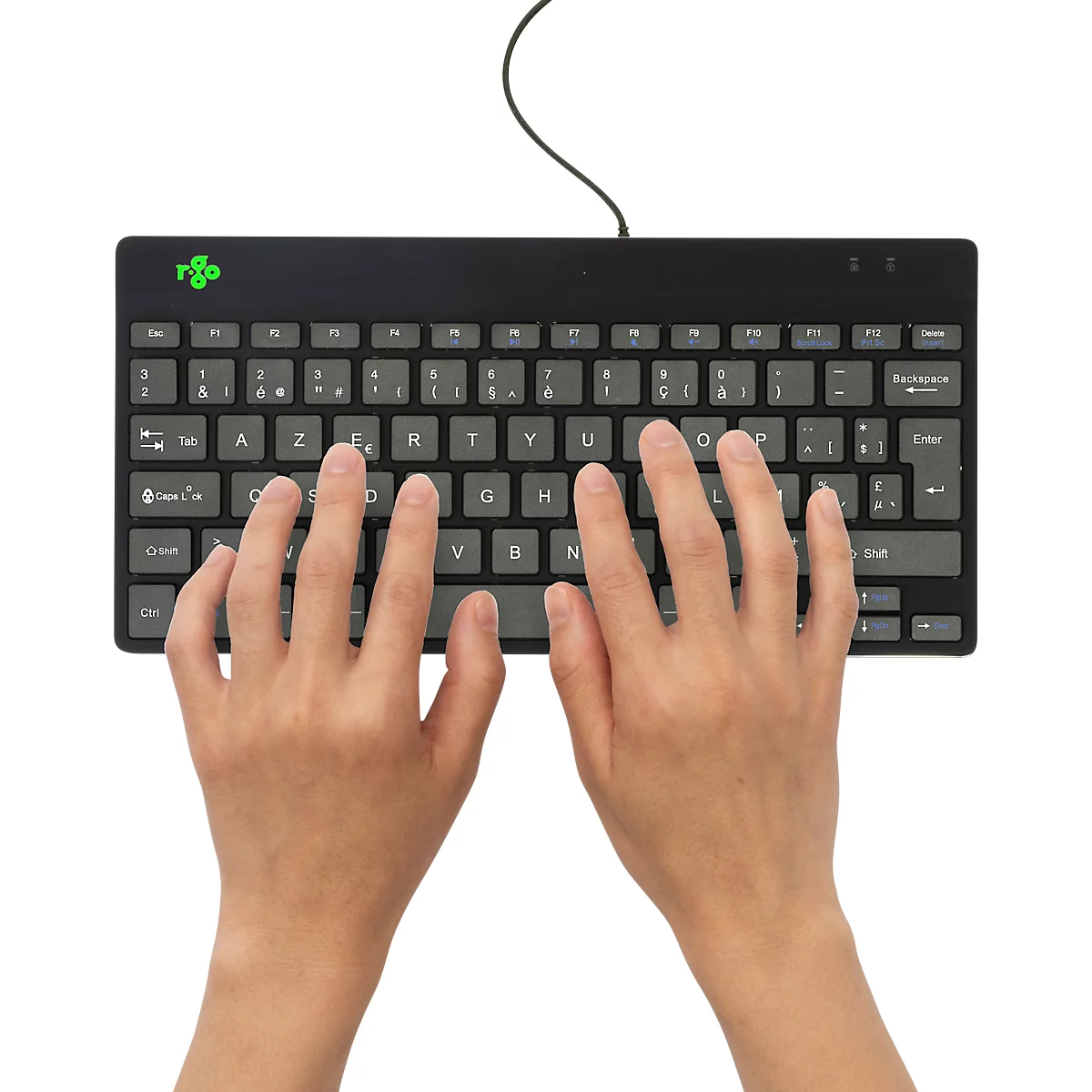 Mains tapant sur un clavier noir. Un fond blanc est visible en arrière-plan. Un câble est connecté en haut.