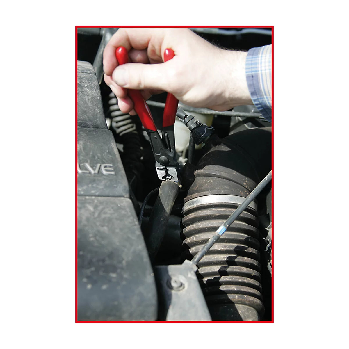 Person hält rote Zange an einem Motor.