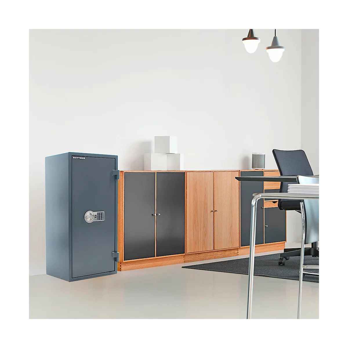 Coffre-fort gris dans un bureau. Armoires, bureau et chaise à côté.