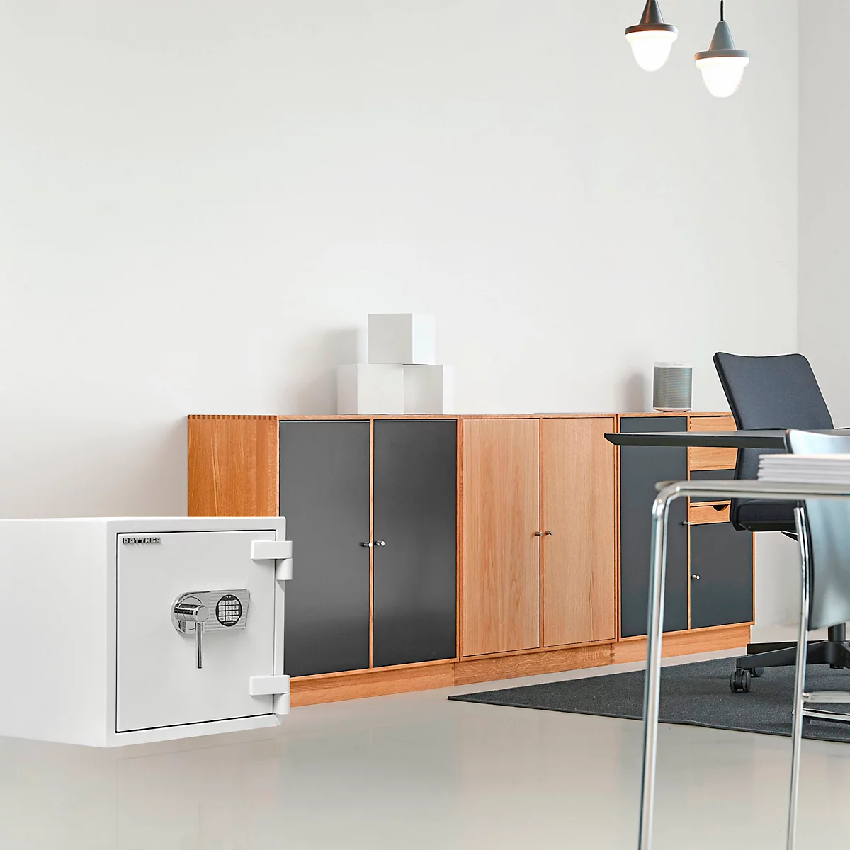 Coffre-fort blanc dans un bureau, devant des armoires et un bureau.