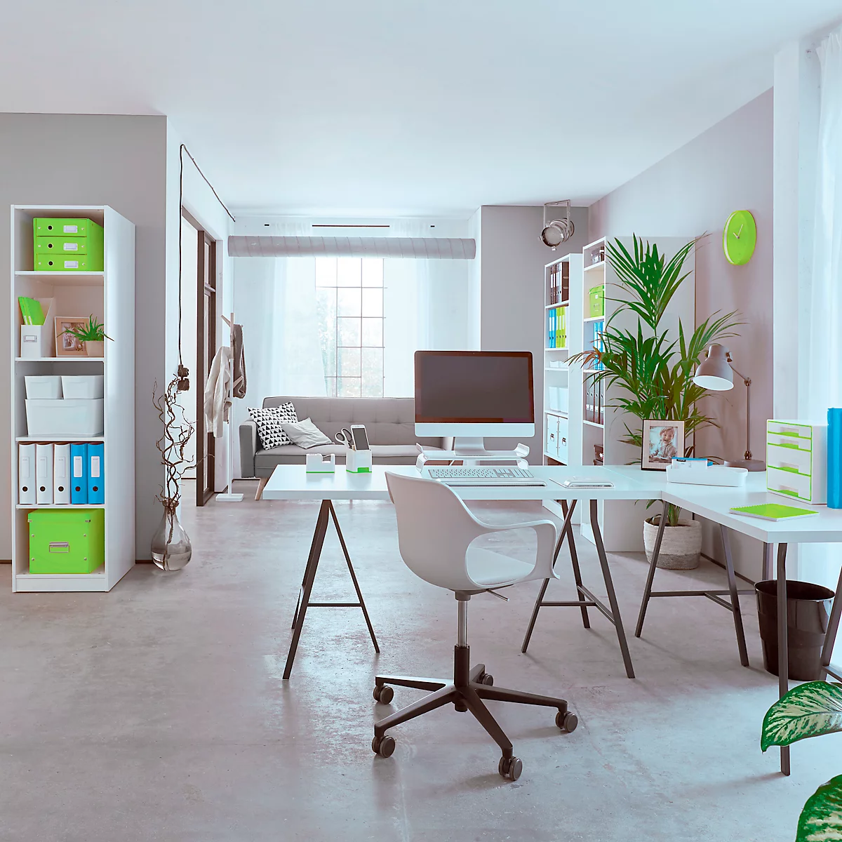 Heller, moderner Arbeitsbereich mit Schreibtisch, Stuhl, Computer und Regal mit Ordnern.