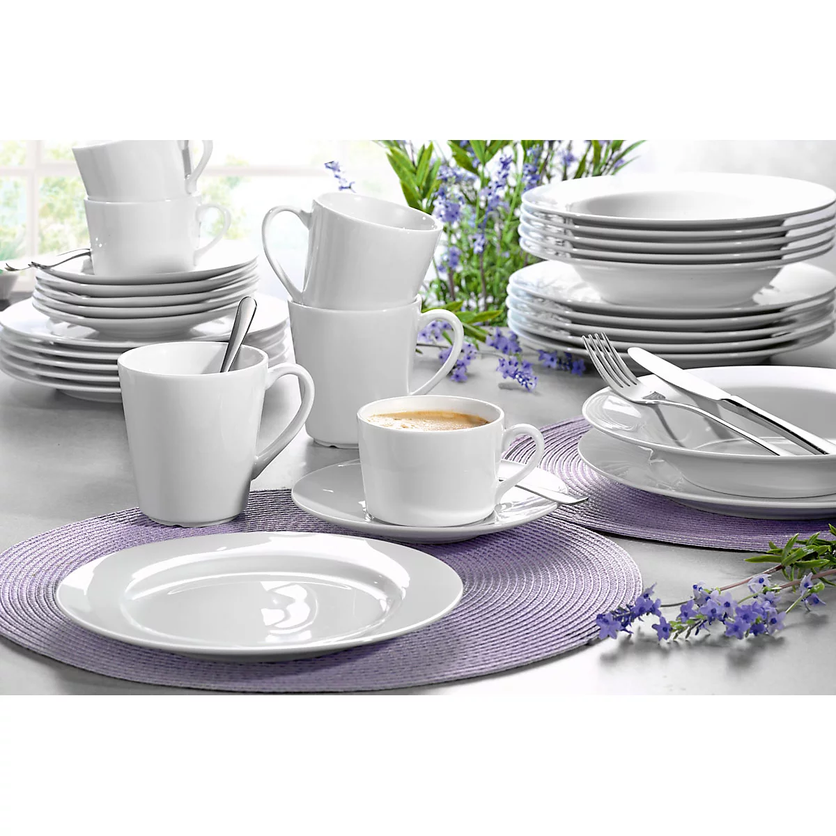 White dishes, cups and plates on purple coasters, set table.
