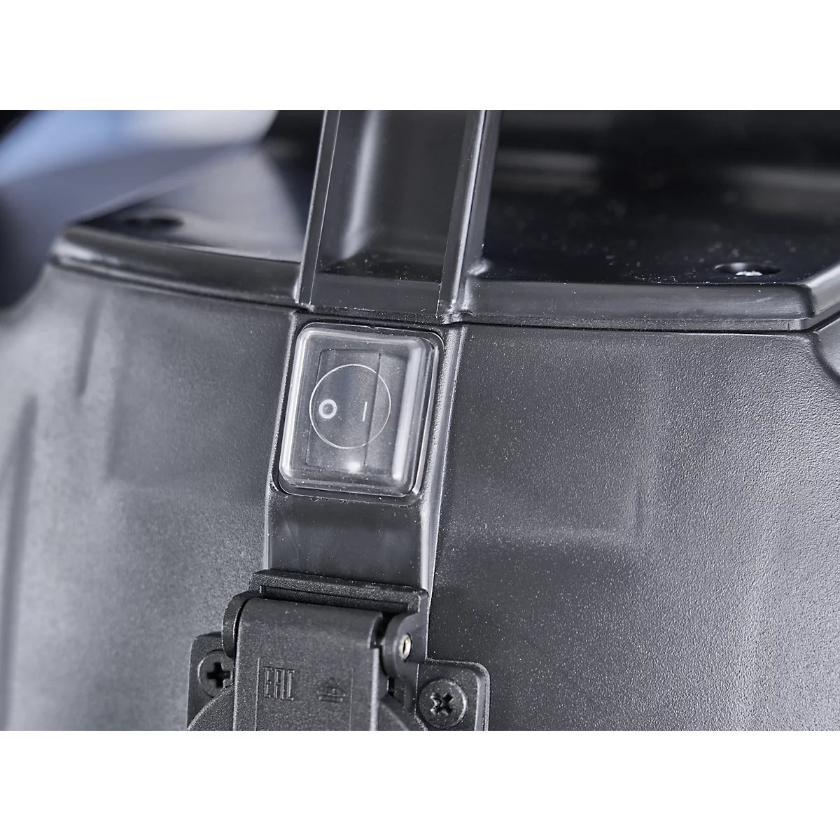 Close-up of a black plastic device. A transparent on/off switch with the characters 0 and I is visible. The handle is black.