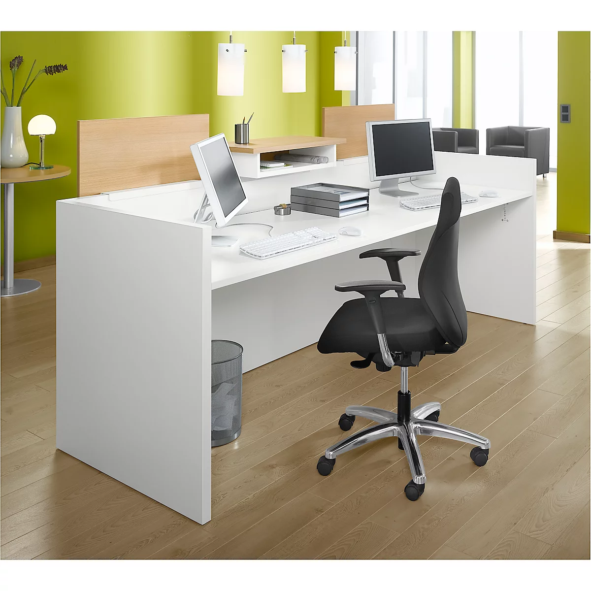 Poste de travail de bureau avec deux moniteurs, un bureau, une chaise, des poubelles et des lampes.