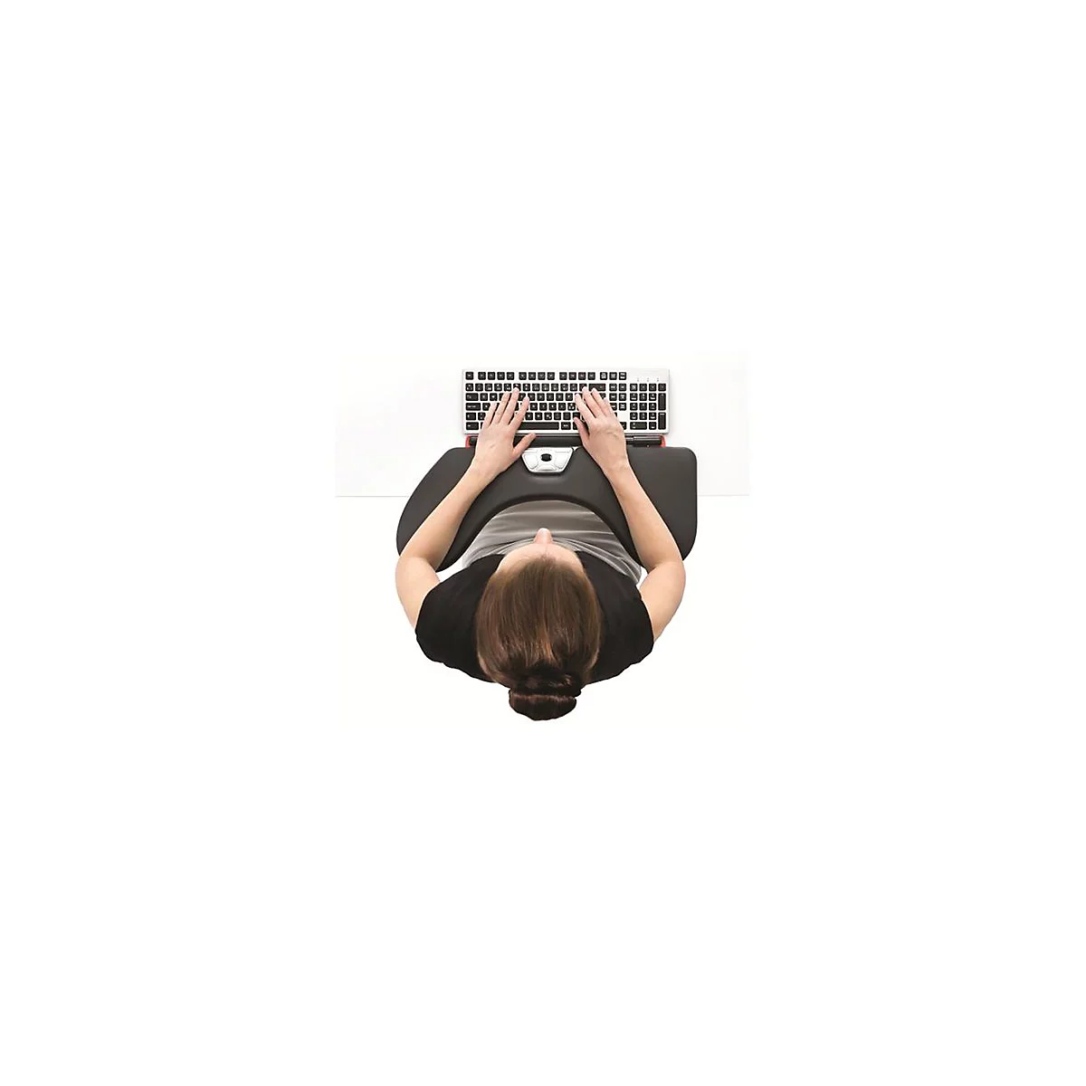 Person tippt auf einer ergonomischen Tastatur, unterstützt durch eine geschwungene, schwarze Armauflage auf einem weißen Tisch.