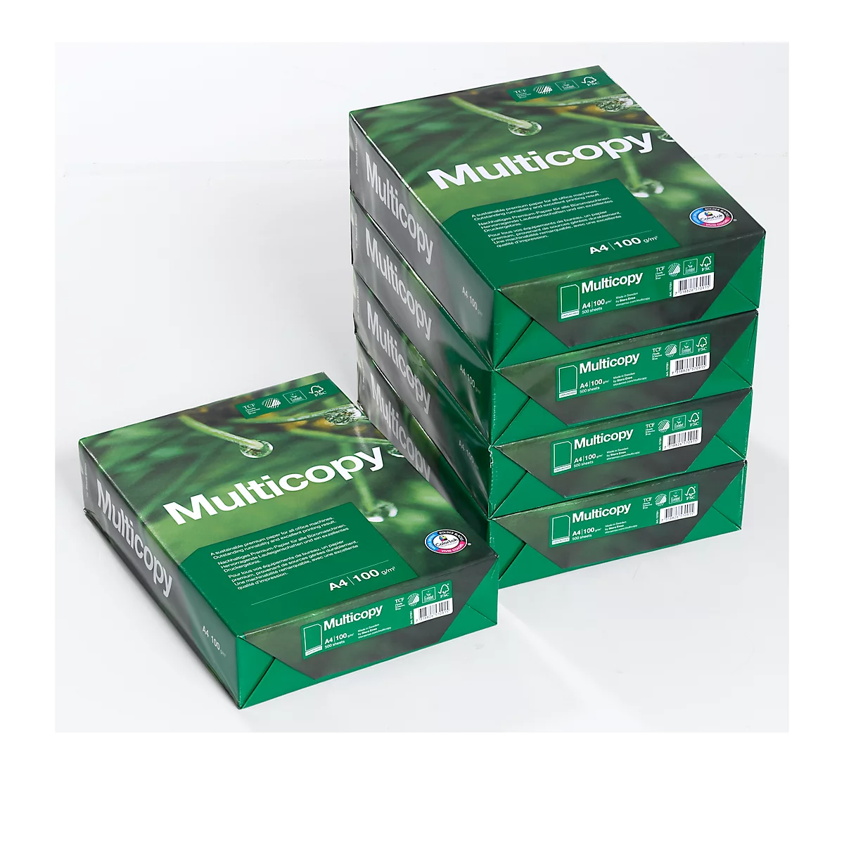 Stack of green Multicopy paper packages. One package lies separately next to it.