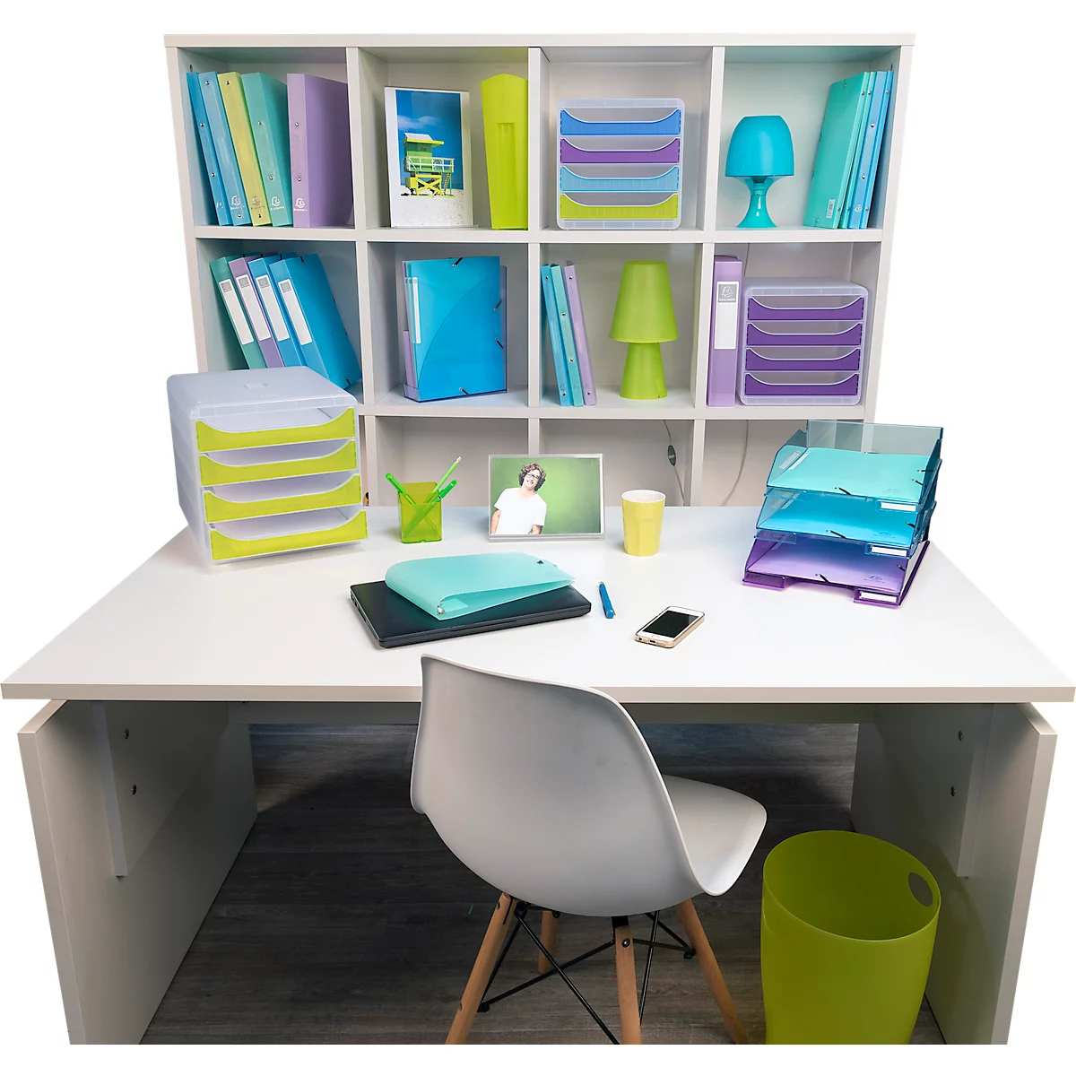 Un bureau avec une chaise, des plateaux, des livres et une lampe. Divers accessoires de bureau aux couleurs vives.