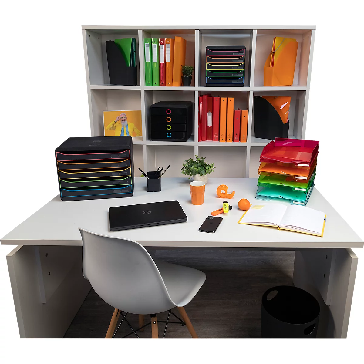 Bureau avec fournitures de bureau : ordinateur portable, stylos, téléphone portable, dossiers, bacs colorés.