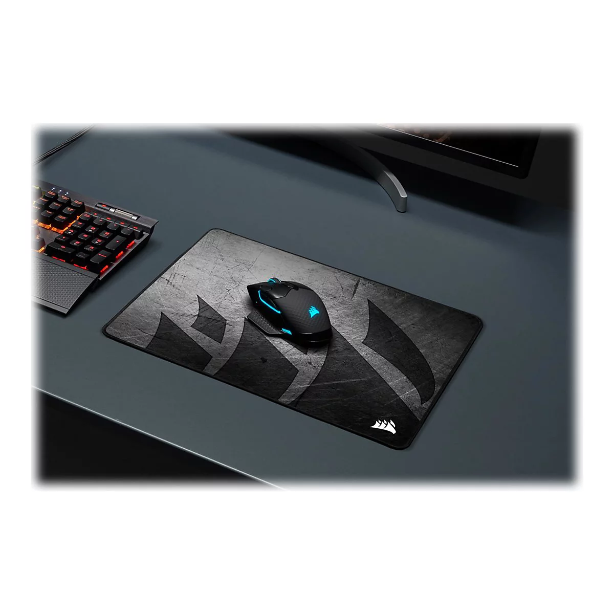 Ein schwarzes Gaming-Mauspad mit Maus und Tastatur, beide beleuchtet auf einem grauen Schreibtisch.