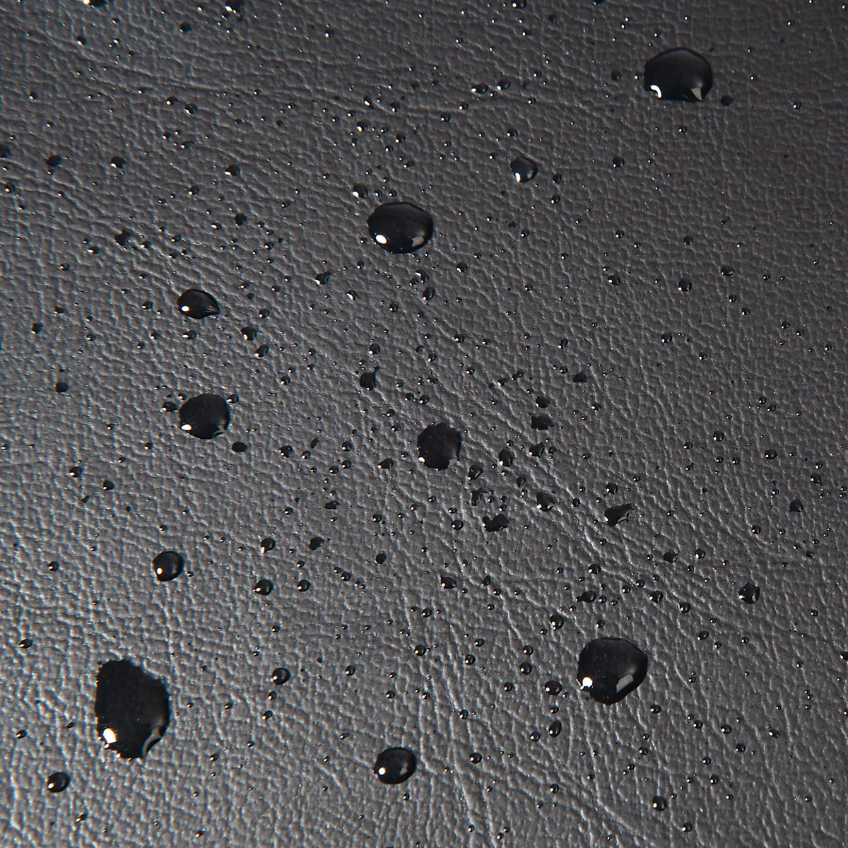 Surface noire, aspect cuir, avec des gouttelettes d'eau.