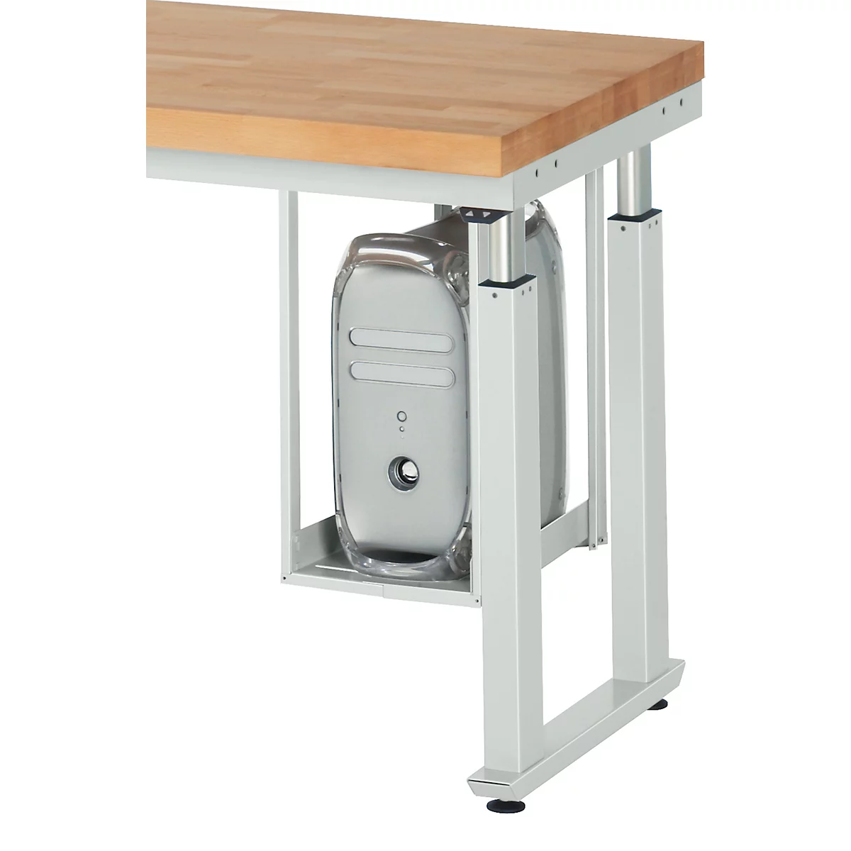 View of a desk with a computer case attached to the underside. The desk frame is silver, the tabletop is made of wood.