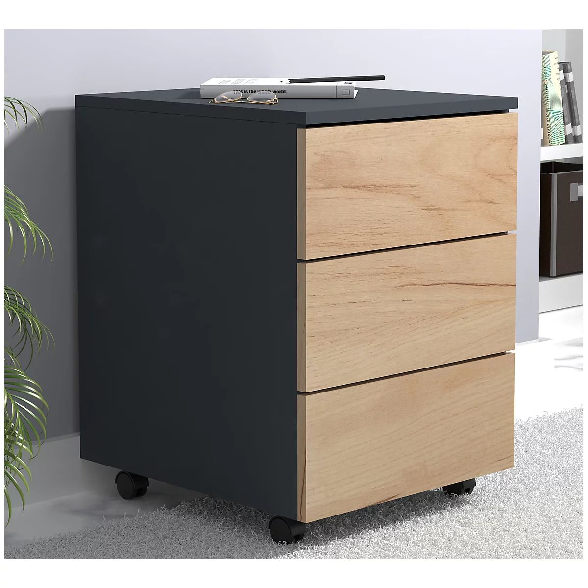 Black file cabinet with three drawers and wooden fronts. It is on wheels, with glasses and a remote control on top.