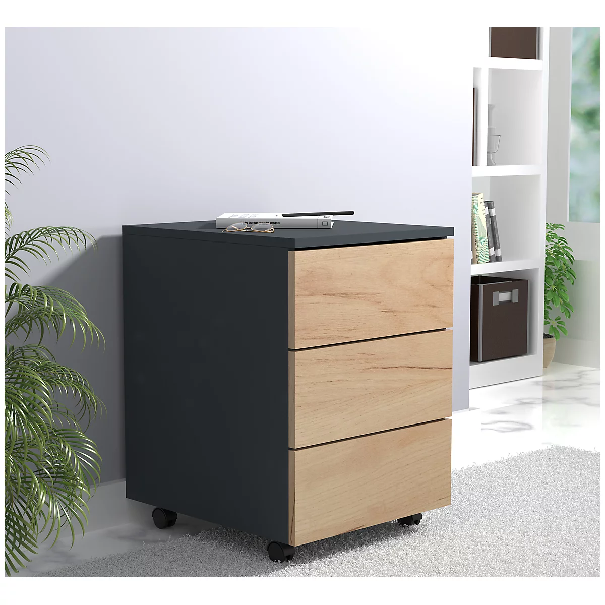 Dark gray filing cabinet with three drawers, wooden fronts, black lid, castors. Glasses and pen on top.